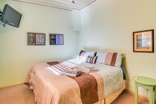 a bedroom with a bed with a tv on the wall at Riverfront Fishing Home in Columbus with Grill in Columbus