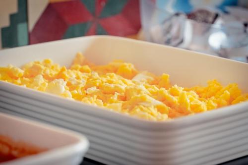 a white dish filled with macaroni and cheese at VELINN Pousada Iguana Azul in Ilhabela