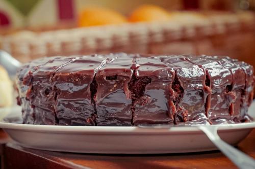 a chocolate cake on a plate on a table at VELINN Pousada Iguana Azul in Ilhabela