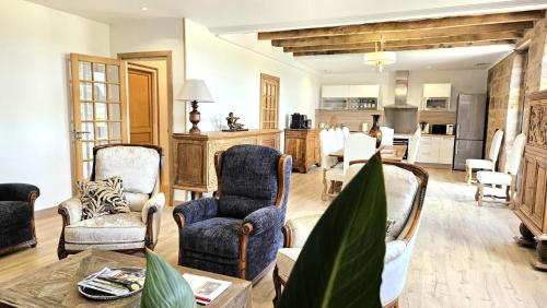 un salon avec des chaises et une table et une cuisine dans l'établissement Gîte de France Le nid des grisets 4 épis - Gîte de France 8 personnes MAE-4591, à Ussac