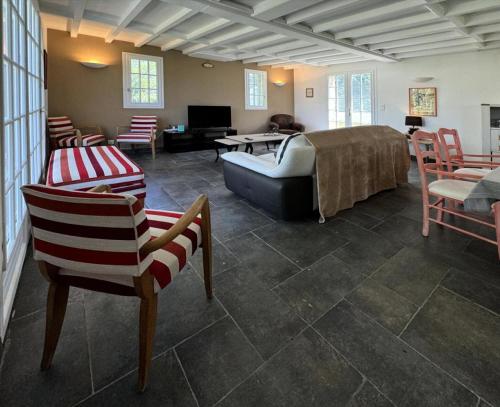 un salon avec un canapé et des chaises dans l'établissement Gîte de France Pool house et tennis 3 épis - Gîte de France 7 personnes MAE-4611, à Brive-la-Gaillarde