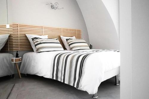 a bedroom with a large white bed with striped pillows at Gîte de France Game of dome - Gîte de France 4 personnes MAE-4601 in Chartrier-Ferrière
