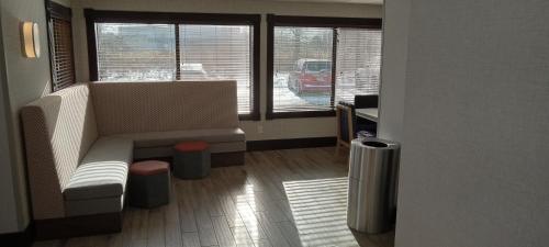 a living room with a couch and two windows at Hampton Inn Birch Run in Birch Run