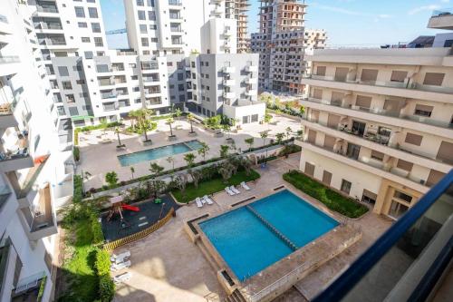 an overhead view of two swimming pools in a city at Cosy appartement 2 BR avec vue panoramique piscine in Aïn Harrouda