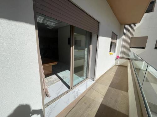an empty balcony of a building with sliding glass doors at Cosy appartement 2 BR avec vue panoramique piscine in Aïn Harrouda
