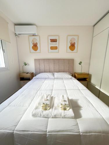 a large white bed with two plates on it at Saavedra 118 6ºI by depptö in Bahía Blanca