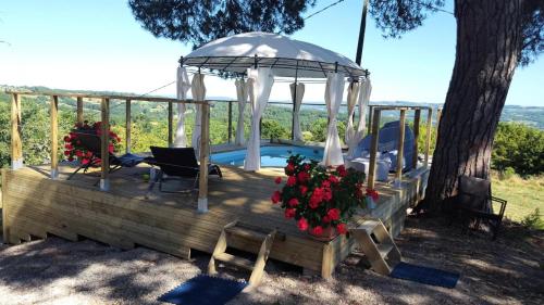 une terrasse en bois avec un kiosque et une piscine dans l'établissement Gîte de France La roulotte - Gîte de France 4 personnes MAE-4651, à Cublac