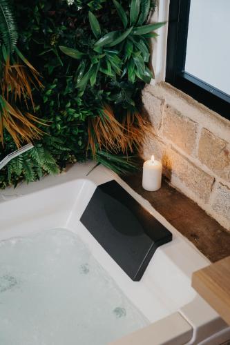 a candle sitting on top of a bath tub with plants at Duplex Lomy vue sur le port avec Sauna-balneo-5mn plage in Pléneuf-Val-André