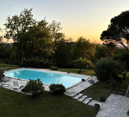 une piscine au milieu d'une cour dans l'établissement Gîte de France Pool house 3 épis - Gîte de France 3 personnes MAE-4641, à Brive-la-Gaillarde