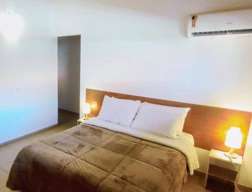 ein Schlafzimmer mit einem großen Bett mit zwei Lampen in der Unterkunft Charmoso Apartamento na Terceira praia de Morro in Morro de São Paulo