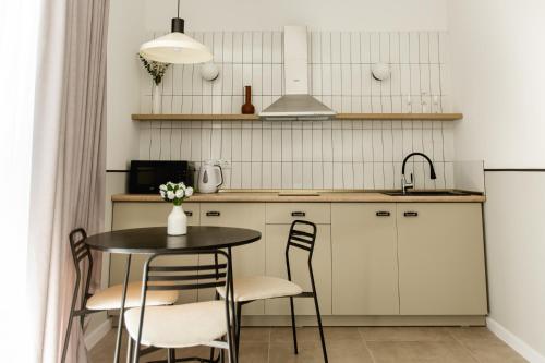 a kitchen with a table and chairs and a sink at Central Inn in Kutaisi