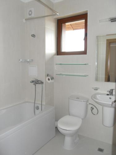 a white bathroom with a toilet and a sink at HillTop Villa in Burgas
