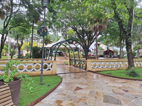 a park with a bridge and trees and a walkway at Apartamento Gracioso ao lado do Parque das Águas in Caxambu