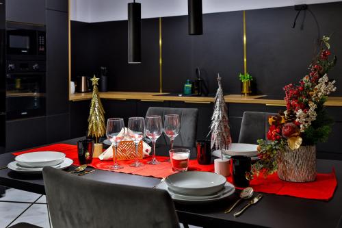 a dining room table with a red tablecloth and christmas decorations at Nowoczesne Apartamenty typu Superior - Bulwary Rabka Zdrój - Balia - Blisko Park Zdrojowy in Rabka