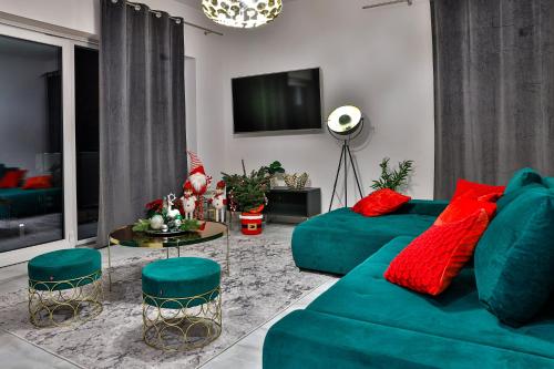 a living room with a green couch and red pillows at Nowoczesne Apartamenty typu Superior - Bulwary Rabka Zdrój - Balia - Blisko Park Zdrojowy in Rabka