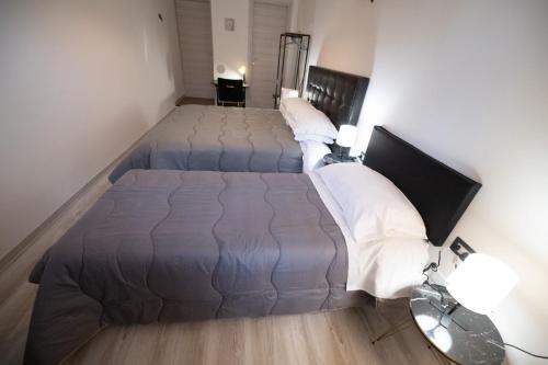 two beds in a room with two lamps and a bed sidx sidx sidx at Luz de Salento B&B in Lecce