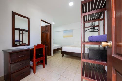 a bedroom with a bunk bed and a desk and a bunk bed at Fuego del Sol Beachfront Hotel in Jacó