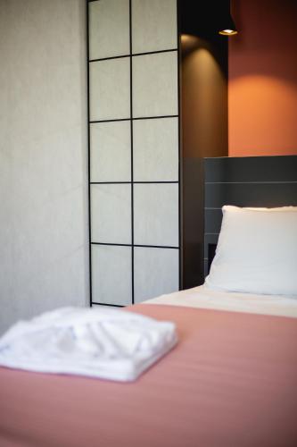a bed with a white pillow on top of it at Central Inn in Kutaisi