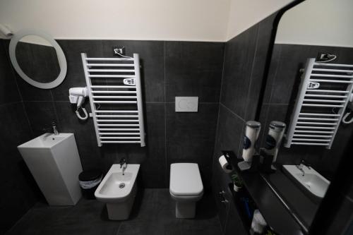 a bathroom with a sink and a toilet and a mirror at Luz de Salento B&B in Lecce