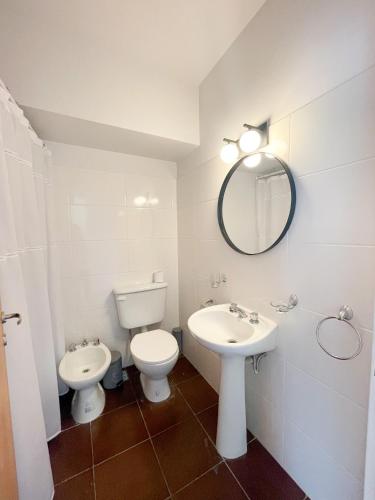 a bathroom with a toilet and a sink and a mirror at Saavedra 118 8D by depptö in Bahía Blanca