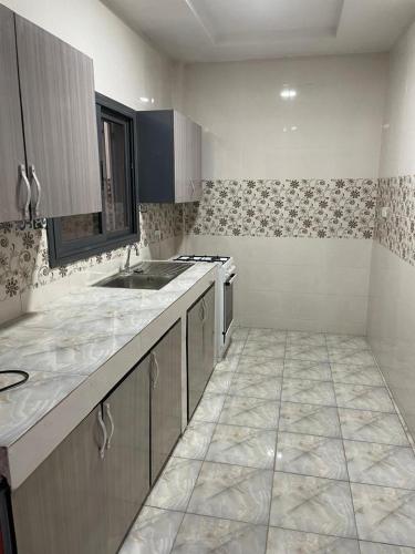 a kitchen with a sink and a counter top at Njai's Apartments A in Brusubi
