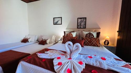 a hotel room with a bed with two towels on it at Pousada Pura vida in Itacaré