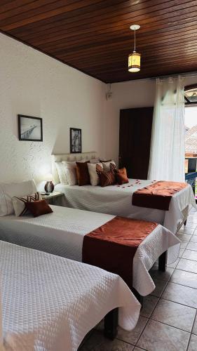 a bedroom with two beds in a room at Pousada Pura vida in Itacaré