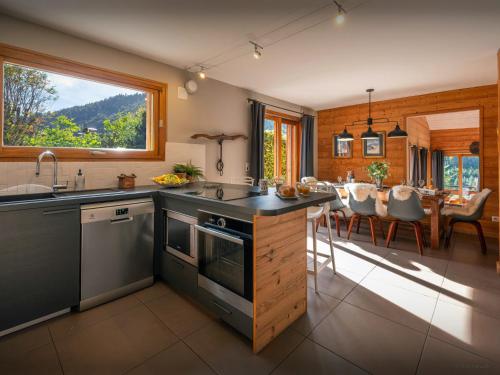 une cuisine avec une grande fenêtre et une salle à manger dans l'établissement Chalet Paravis - OVO Network, à La Clusaz