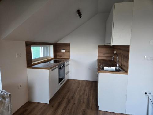 an attic kitchen with white cabinets and a sink at Agregat in Ljubljana