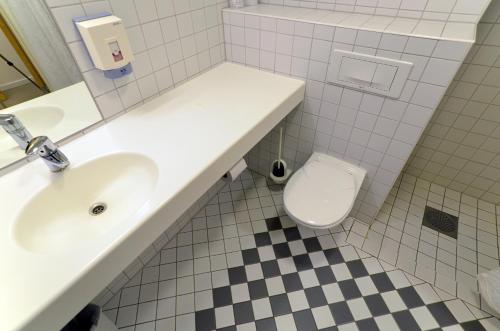 a bathroom with a white sink and a toilet at Zefyr Hotel in Bodø