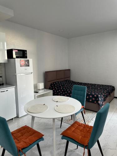 a room with a table and chairs and a bed at Lovely Apartment in City Center in Batumi