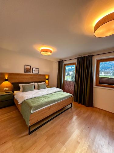 ein Schlafzimmer mit einem großen Bett und zwei Fenstern in der Unterkunft Apart Hartl in Ried im Zillertal