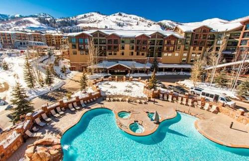 a resort with a swimming pool in the snow at The Grand Summit Hotel in the Canyons Village - Walk to Ski Lift - Pool, Gym, Spa, More! in Park City