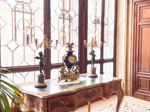 a table with a clock on it in a room with windows at Hotel Ai Cavalieri di Venezia in Venice