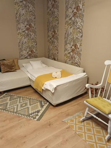 a bedroom with a large bed and a chair at Kata Belvárosi Apartman in Veszprém