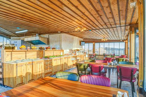 una cucina con armadi in legno e sedie colorate di Unique Cappadocia Palace a Göreme