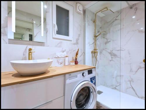 une salle de bain avec un lavabo et une machine à laver dans l'établissement L'Ecrin Nature, au Cap d'Agde