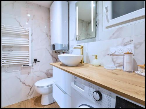 un bagno bianco con lavandino e WC di L'Ecrin Nature a Cap d'Agde
