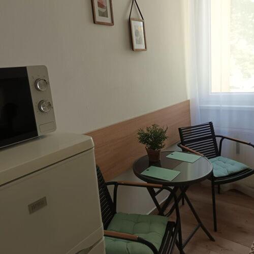 a living room with a table and chairs and a small table with a small table at Kata Belvárosi Apartman in Veszprém