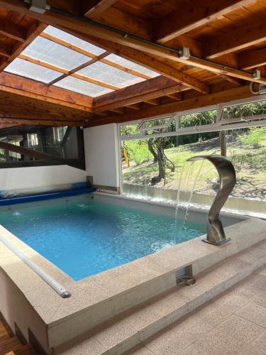 a swimming pool with a water fountain at Cabañas La Frontera in Villa General Belgrano