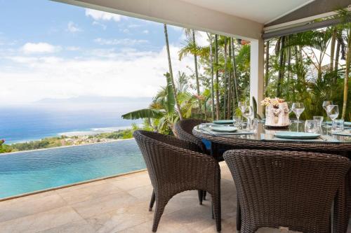 a table and chairs with a view of the ocean at Villa Ireina magnificent sea view in Punaauia