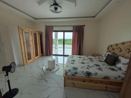 a bedroom with a bed and a large glass door at Villa Hawa, Décor unique & Piscine in Somone
