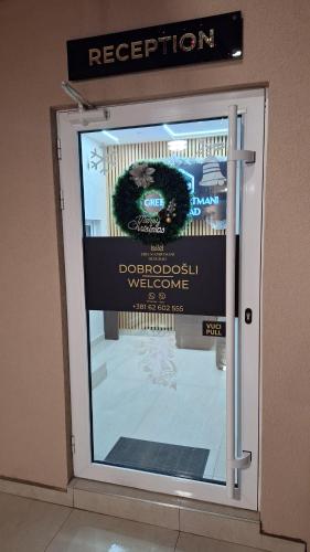 a display window of a door with a sign on it at Apartments Green Beograd in Borča