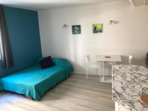 une petite chambre avec un lit et une table dans l'établissement Studio centre ville Vichy, à Vichy
