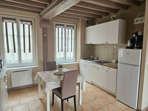 une cuisine avec une table et un réfrigérateur blanc dans l'établissement A la Terrasse coeur Honfleur, à Honfleur