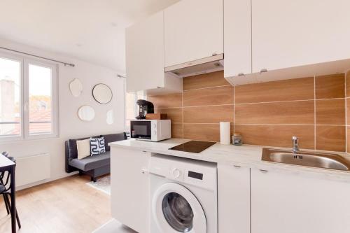 une cuisine avec une machine à laver et un évier dans l'établissement Gentilly Beau T2 aux Porte de Paris RER B, à Gentilly