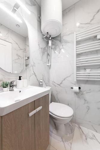 une salle de bain blanche avec des toilettes et un lavabo dans l'établissement Gentilly Beau T2 aux Porte de Paris RER B, à Gentilly