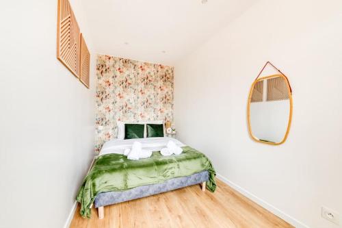 une petite chambre avec un lit et un miroir dans l'établissement Gentilly Beau T2 aux Porte de Paris RER B, à Gentilly