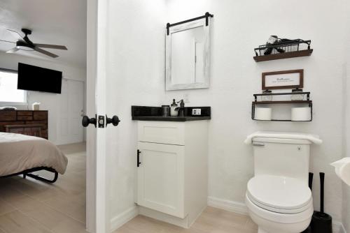 a white bathroom with a toilet and a mirror at Cozy Studio Suite Near Beach W Kitchenette #11 in Daytona Beach Shores