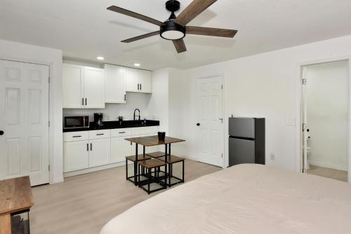 a kitchen with white cabinets and a ceiling fan at Cozy Studio Suite Near Beach W Kitchenette #11 in Daytona Beach Shores
